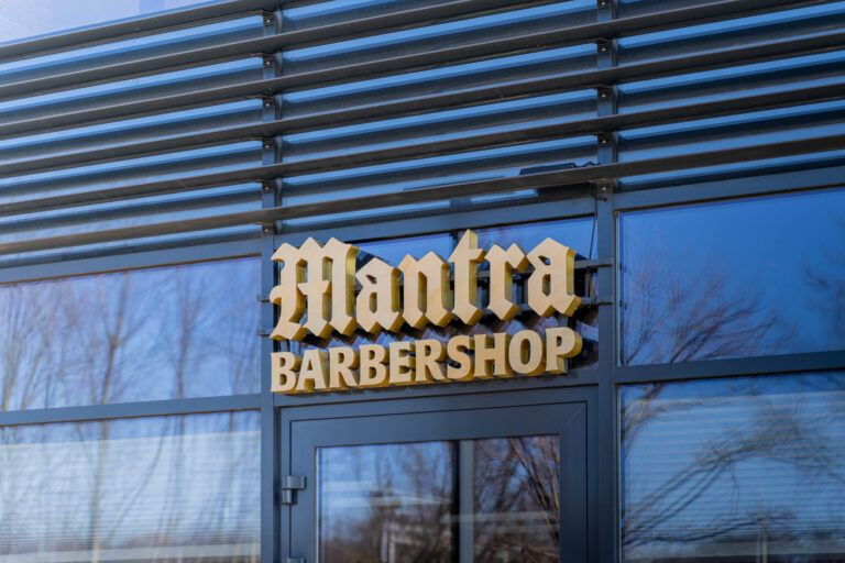 Litery 3D nad wejściem do barbershopu na przeszklonej elewacji