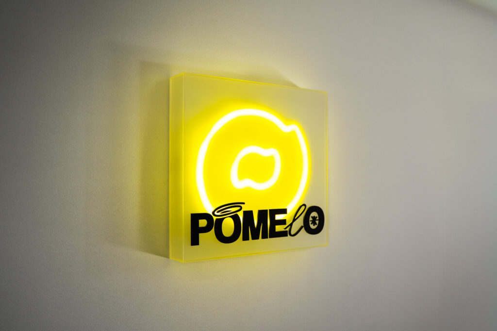 Lightbox z neonem LED i żółtym licem z plexi na ścianie wnętrza
