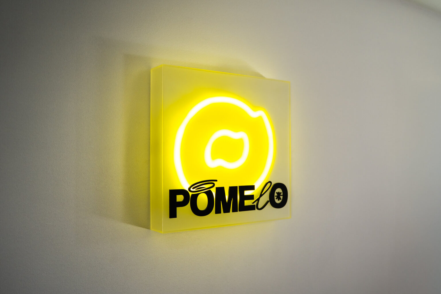 Lightbox z neonem LED i żółtym licem z plexi na ścianie wnętrza