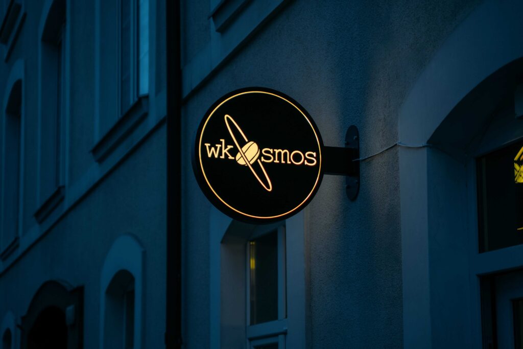 Semafor reklamowy dla kawiarni widoczny wzdłuż ulicy o zmroku